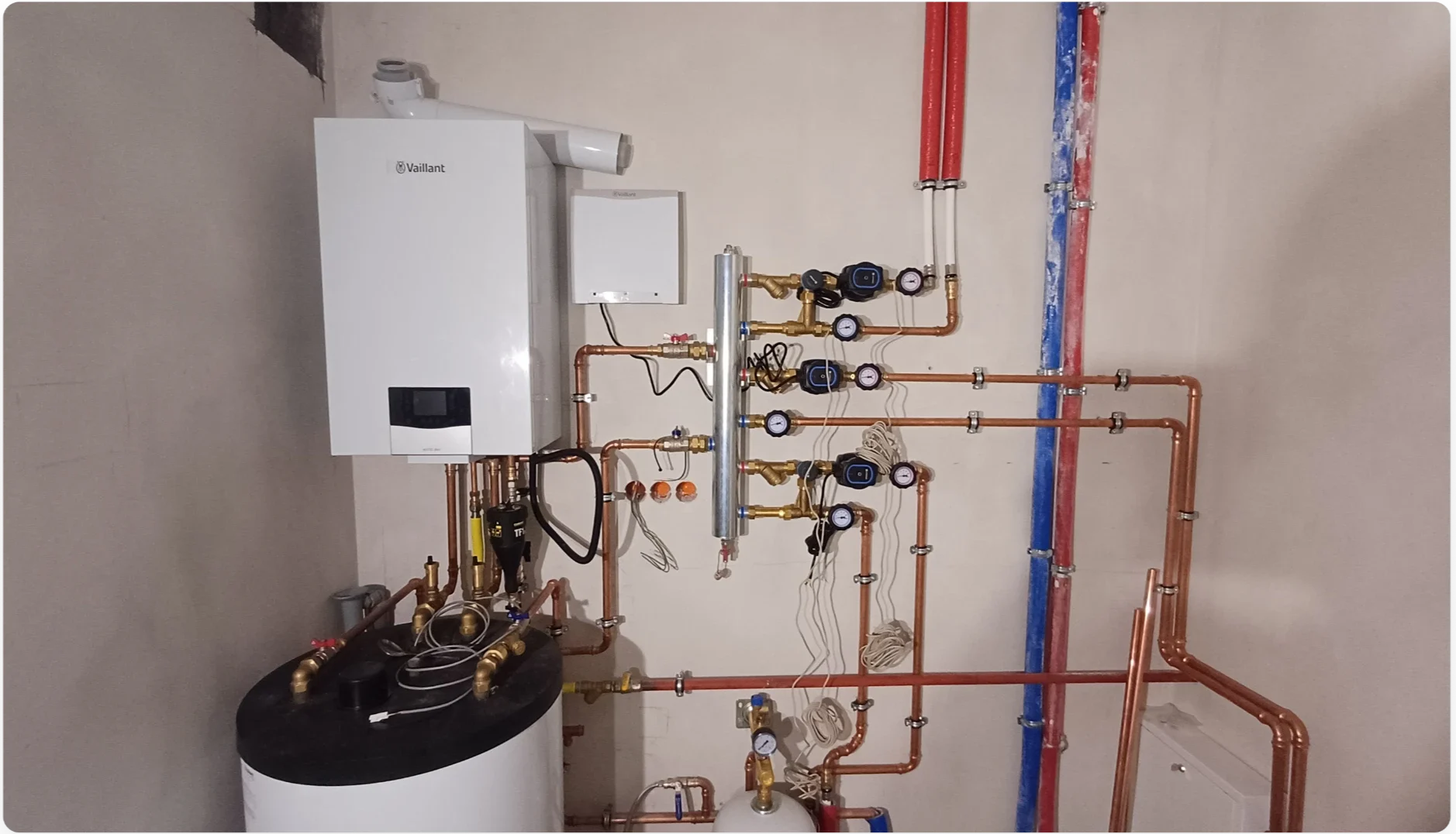 Ścienna instalacja kotłowa z rozdzielaczem, miedzianymi rurami i pompami – Instalacje grzewcze